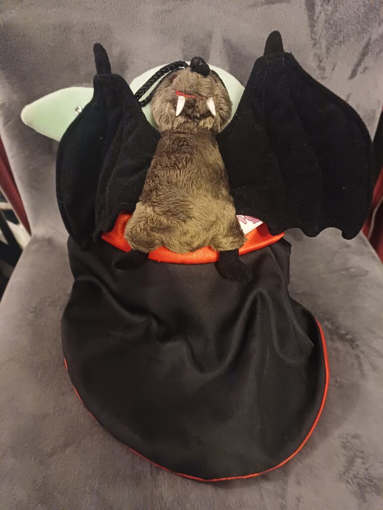 Rückseite des Grogus mit dem schwarzen Cape, an dem eine Plüschfledermaus mit Sicherheitsnadeln befestigt ist.